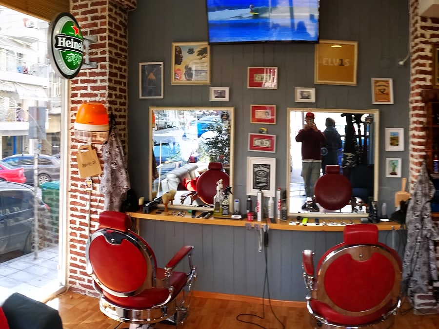 Το εσωτερικό του The Barber Club με vintage κόκκινη καρέκλα και τούβλο